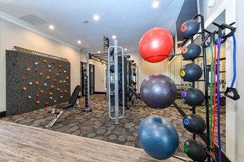 a gym with a wall of fitness equipment and a punching bag at Artesian on Westheimer, Houston, 77077